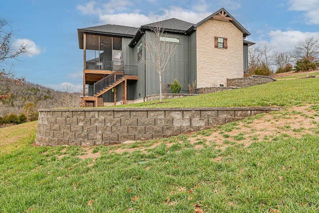 back of property with a sunroom and a lawn