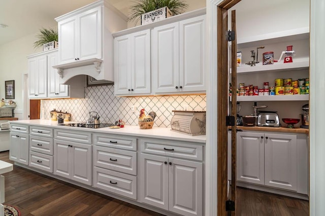 kitchen with decorative backsplash, white cabinetry, black electric stovetop, and dark hardwood / wood-style floors