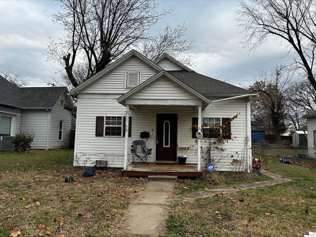 bungalow-style house with central AC unit and a front yard