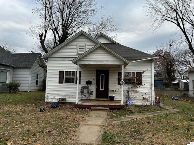 bungalow-style house with central AC unit and a front yard