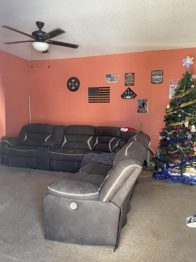 carpeted living room featuring ceiling fan and a textured ceiling