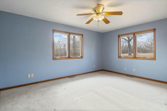 carpeted spare room with ceiling fan and a healthy amount of sunlight