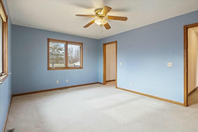 empty room with ceiling fan and light carpet