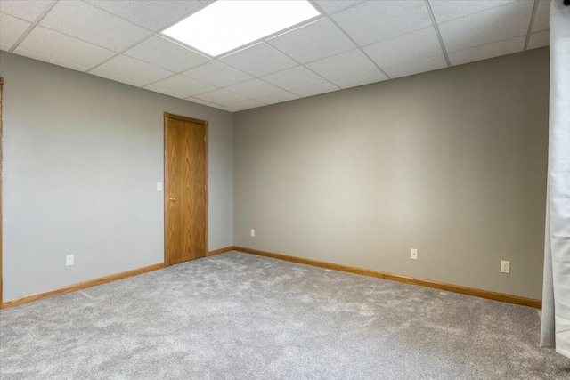 carpeted empty room with a drop ceiling