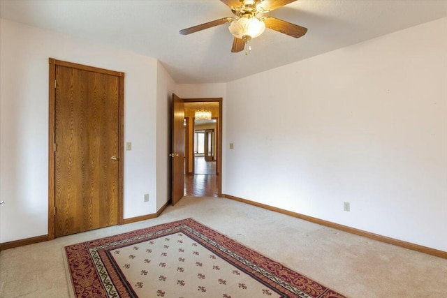 carpeted spare room with ceiling fan