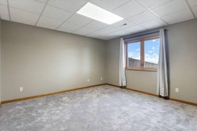 unfurnished room featuring carpet and a paneled ceiling