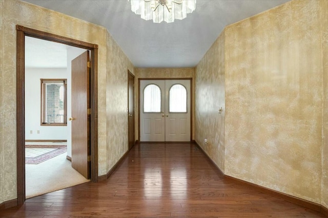 entrance foyer with dark hardwood / wood-style flooring and a notable chandelier