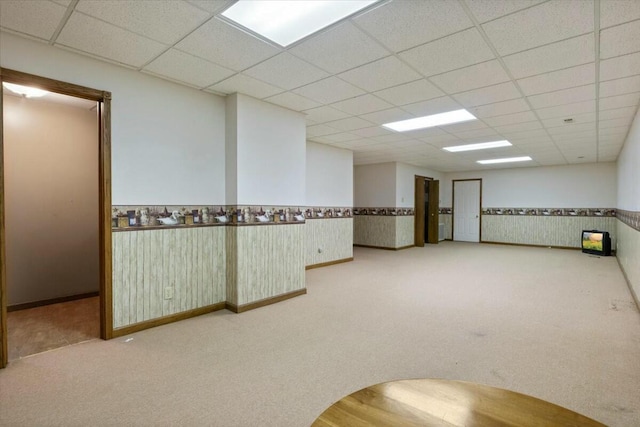 carpeted spare room with a paneled ceiling