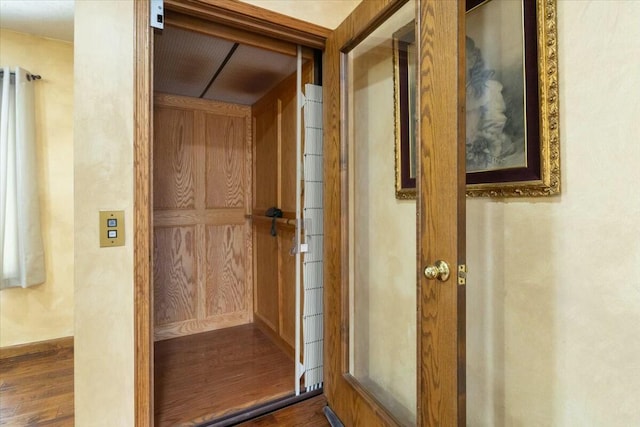 interior space with dark wood-type flooring and elevator