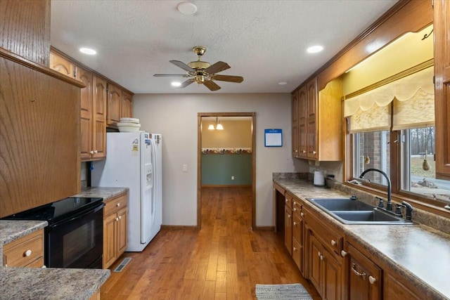 kitchen with black range with electric stovetop, sink, ceiling fan, a textured ceiling, and light hardwood / wood-style floors