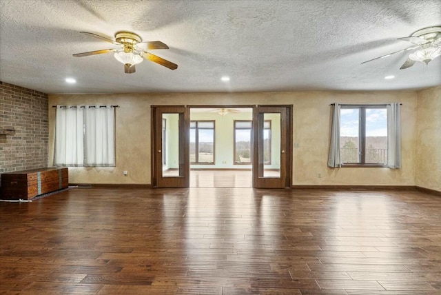 unfurnished living room featuring dark hardwood / wood-style flooring and a textured ceiling