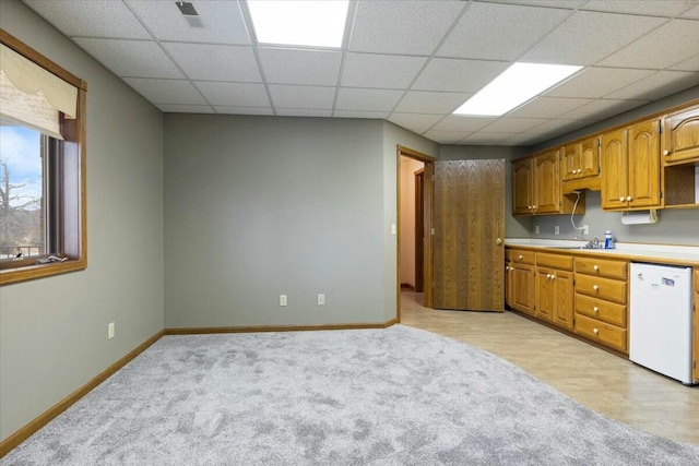 kitchen with sink, dishwasher, a drop ceiling, and light hardwood / wood-style flooring