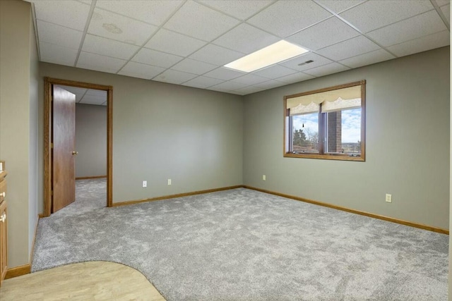 carpeted spare room with a paneled ceiling