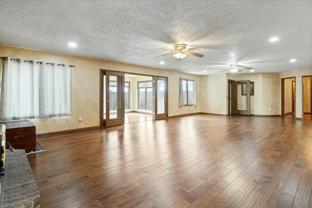 unfurnished living room featuring french doors, a textured ceiling, dark hardwood / wood-style flooring, and ceiling fan