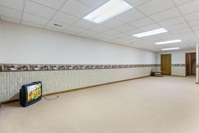 basement featuring a paneled ceiling and carpet