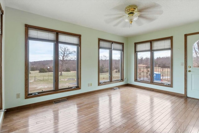 interior space with light hardwood / wood-style flooring, a wealth of natural light, and ceiling fan