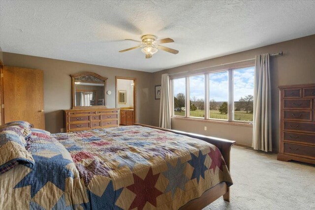 carpeted bedroom with ceiling fan and a textured ceiling