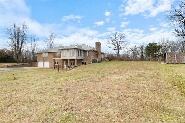 view of yard with a garage and central AC