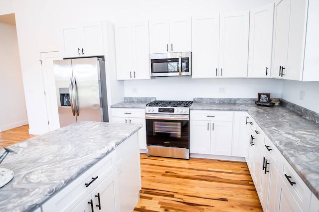 kitchen featuring white cabinets, light wood-type flooring, and appliances with stainless steel finishes