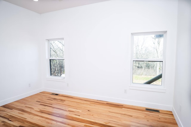 spare room featuring hardwood / wood-style floors and a wealth of natural light