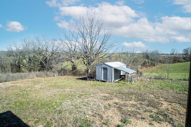 view of yard with a rural view and a storage unit