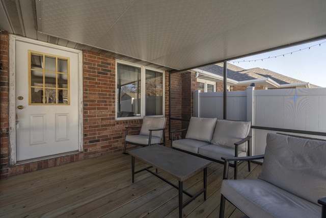 wooden terrace with an outdoor living space