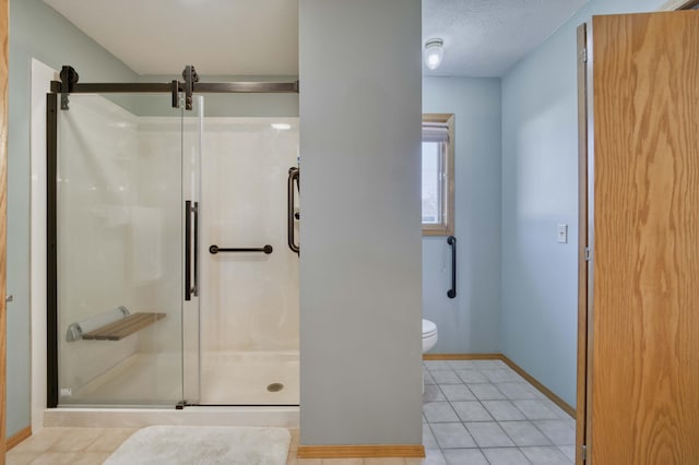 bathroom with tile patterned floors, toilet, a shower with shower door, and a textured ceiling