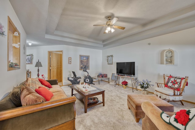 living room featuring ceiling fan, a raised ceiling, carpet floors, and a textured ceiling