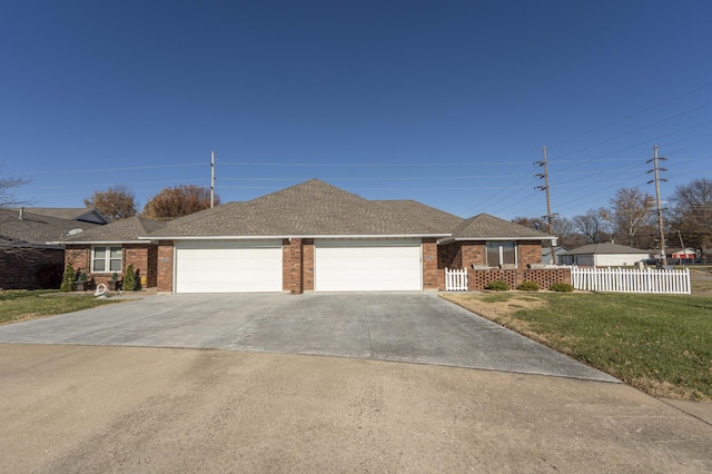 ranch-style house featuring a garage and a front lawn