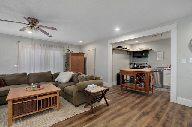 living room with dark hardwood / wood-style flooring and ceiling fan