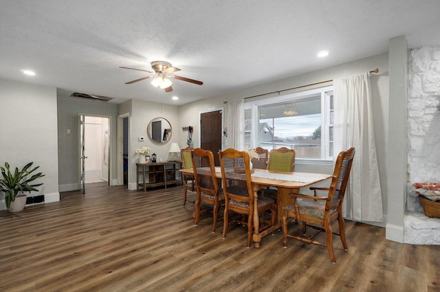 dining room with a textured ceiling, ceiling fan, and dark wood-type flooring