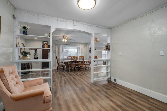 living room with ceiling fan and dark wood-type flooring