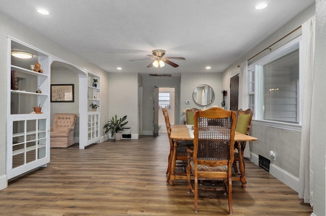 dining room with ceiling fan, dark hardwood / wood-style flooring, and a textured ceiling