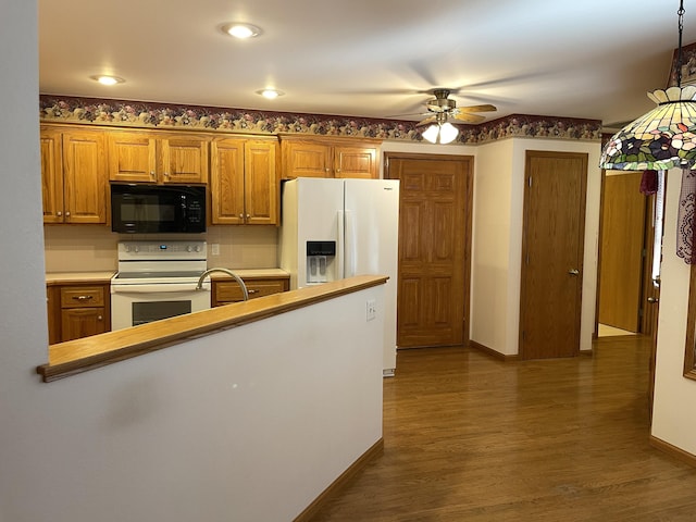 kitchen featuring pendant lighting, white appliances, dark hardwood / wood-style floors, and ceiling fan