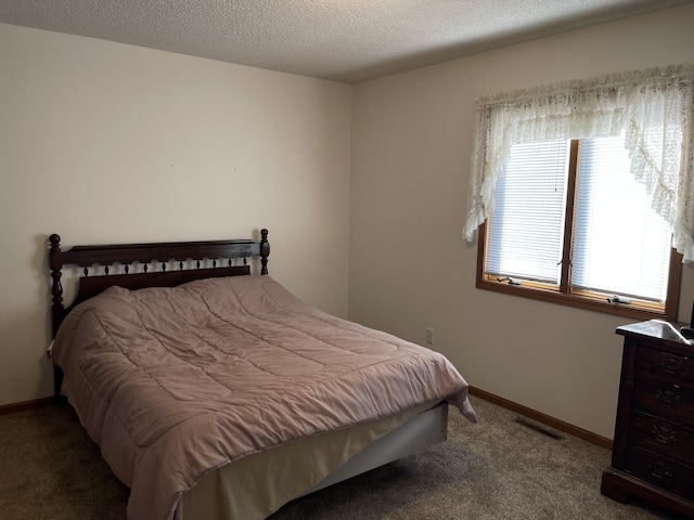 bedroom featuring carpet and a textured ceiling