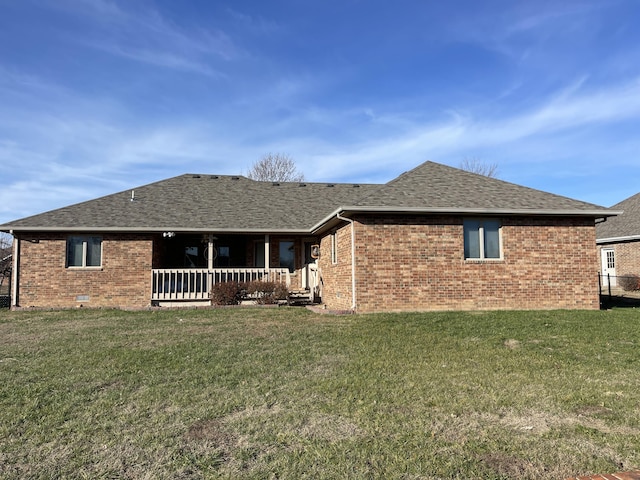 rear view of house featuring a porch and a lawn