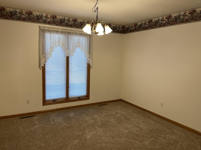 carpeted empty room featuring a textured ceiling and an inviting chandelier