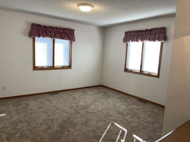 carpeted spare room with a textured ceiling