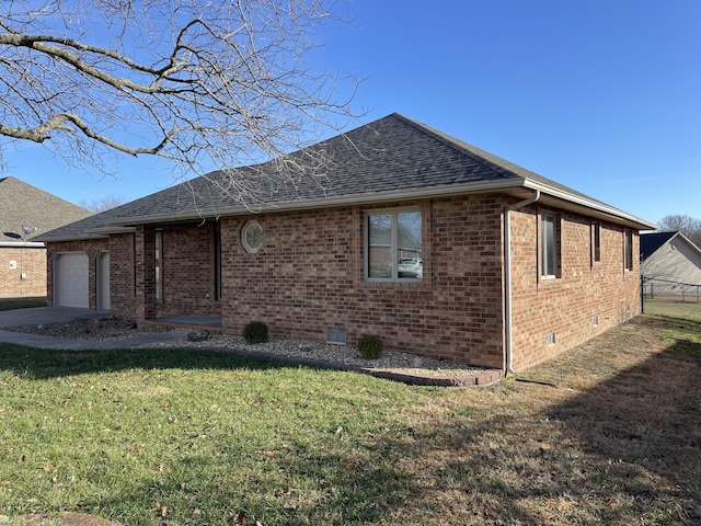 rear view of house featuring a garage and a yard