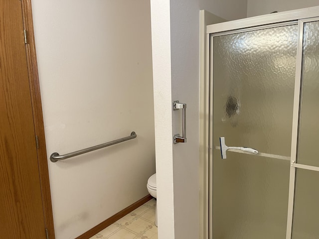 bathroom with toilet and a shower with door