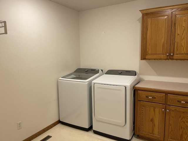 washroom with cabinets and washing machine and dryer