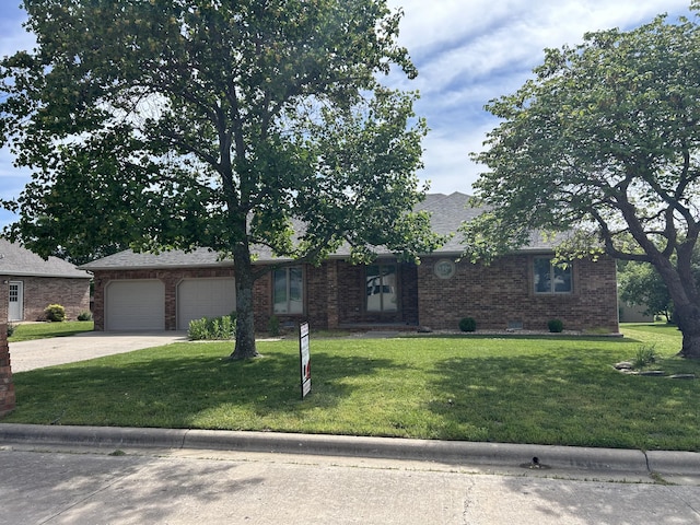 1660 S Meadow Ln, Bolivar, MO 65613 - view of front of house with driveway, brick siding, a garage, and a front lawn