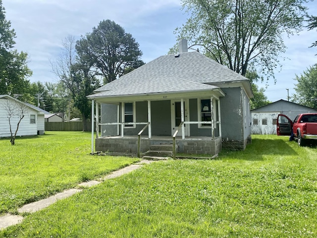 bungalow-style home featuring covered porch and a front yard