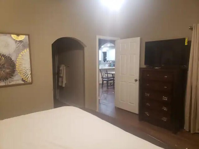 bedroom featuring ensuite bathroom and dark hardwood / wood-style floors