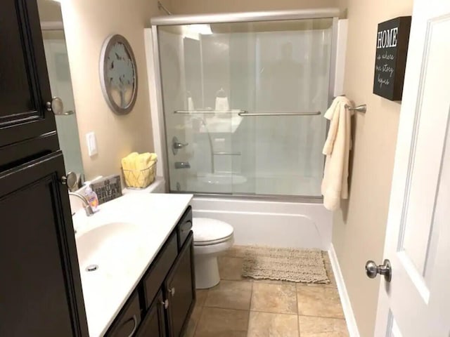 full bathroom with tile patterned flooring, toilet, vanity, and combined bath / shower with glass door