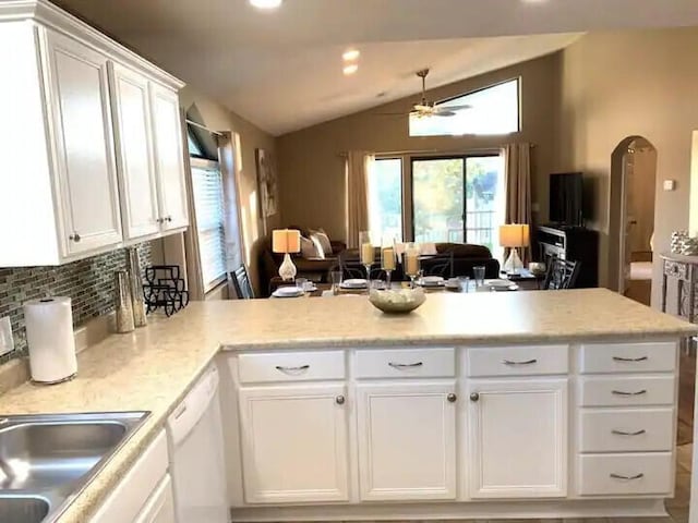 kitchen featuring kitchen peninsula, white dishwasher, white cabinets, and vaulted ceiling