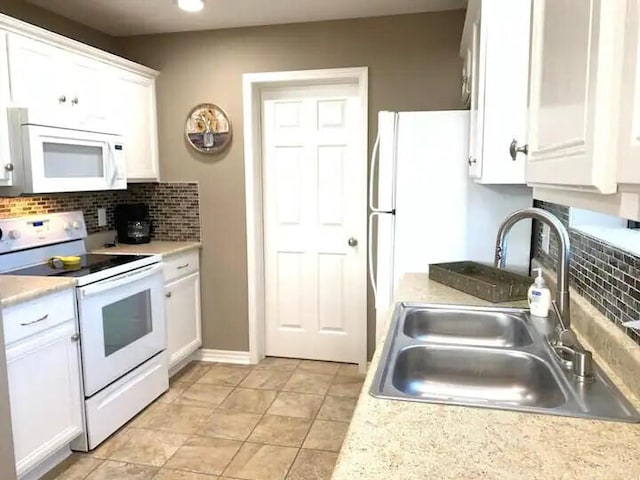 kitchen with white cabinets, decorative backsplash, white appliances, and sink