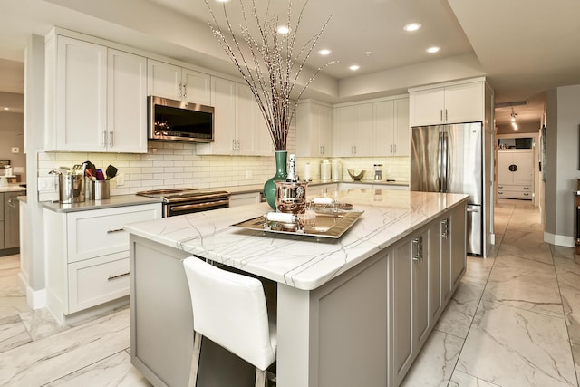 kitchen featuring white cabinets, stainless steel appliances, and a spacious island