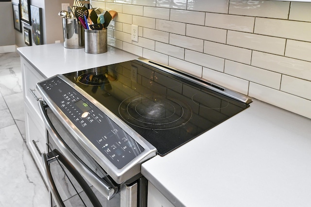 details featuring backsplash and white cabinets