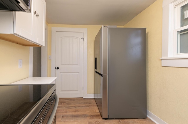 kitchen featuring white cabinets, stainless steel appliances, and light hardwood / wood-style floors